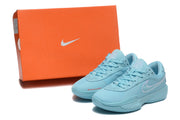 Light-blue Nike G.T. Cut Academy shoes displayed beside an orange Nike shoebox