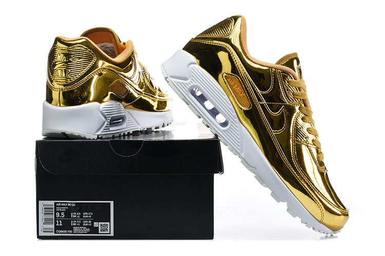 Gold-tone Nike Air Max 90 QS sneakers shown beside a shoe box with a size label.