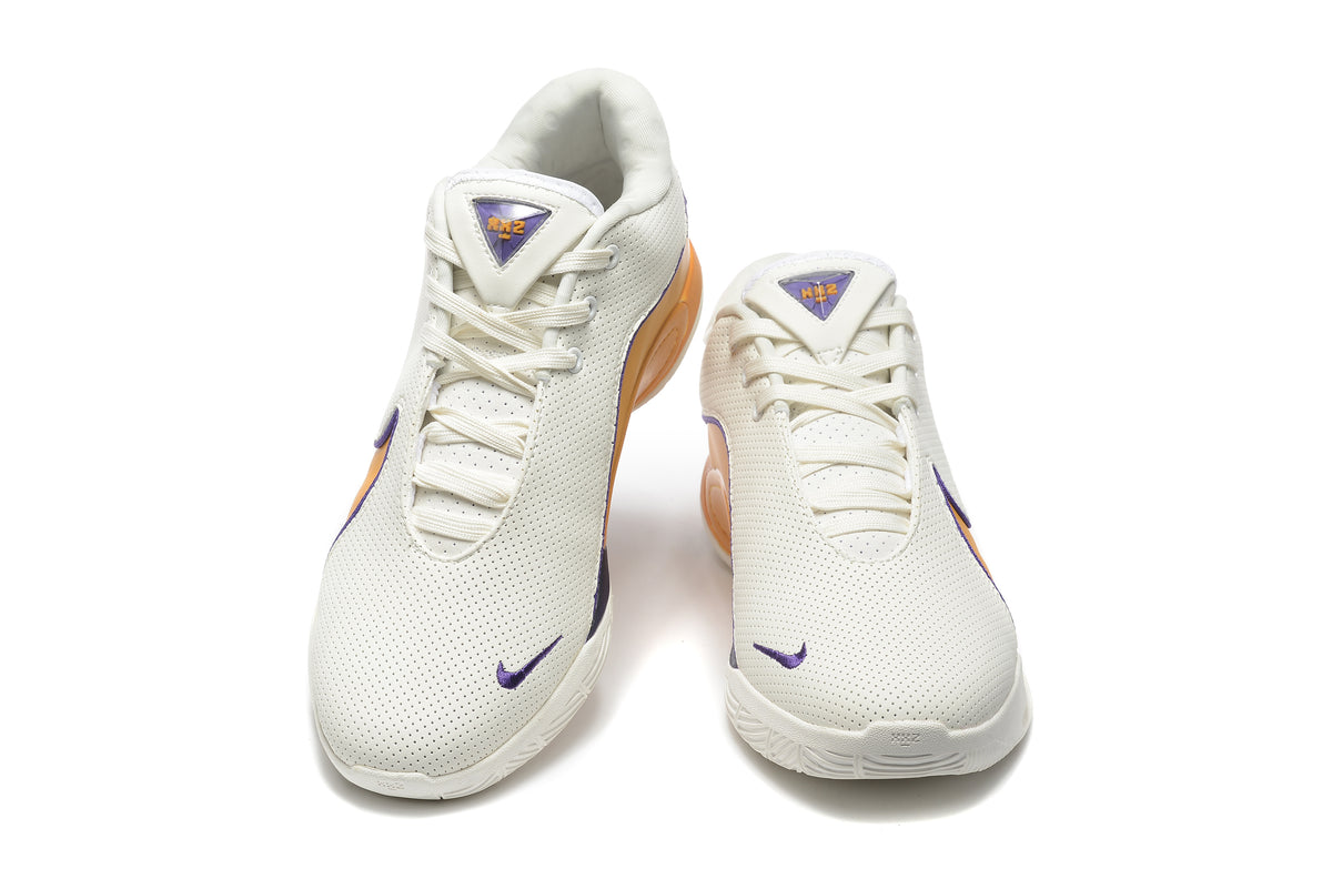 Pair of white Nike sneakers shown from the front, with purple accents and gold-orange side panels.