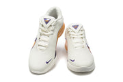 Pair of white Nike sneakers shown from the front, with purple accents and gold-orange side panels.
