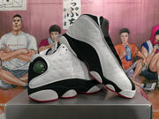 Angled view of the pair highlighting the perforated white panels, black sections, red outsole accents and circular side detail.