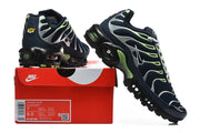 Navy Nike Air Max Plus sneakers with silver and lime-green accents displayed on a box; shoebox label visible.