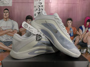 Pair of white and grey Nike basketball sneakers shown from the side, with metallic silver Swooshes and layered panel detailing.