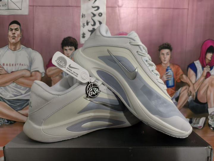 Pair of white and grey Nike basketball sneakers shown from the side, with metallic silver Swooshes and layered panel detailing.