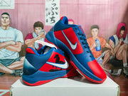 Angled view of the pair displaying the side graphics, white Swooshes, blue overlays, and red outsoles.