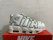 Side view showing oversized AIR lettering on white Nike sneakers with green accents