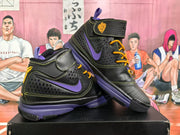 Pair of black and purple high-top basketball sneakers shown together, featuring yellow laces, ankle straps, and contrast detailing.