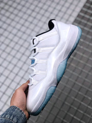 Side view of a white Jordan Air Jordan 11 Low sneaker with a translucent blue outsole and black collar detail.