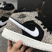 Close side view highlighting the leopard-print overlay, black quarter panel, white Swoosh, and Jordan Wings detail.