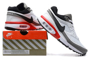 Nike Air Max sneakers in white, grey, black, and red, pictured with a shoe box.