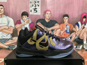 Side view of a dark purple Nike basketball sneaker with prominent gold side detailing, black trim and a translucent outsole.