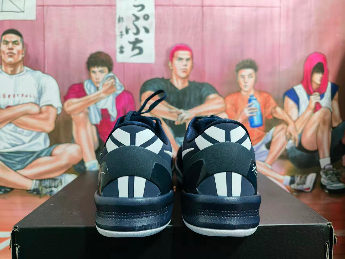 Rear view of navy blue sneakers showing white heel accents, black midsoles, and white outsole edges.