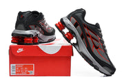 Nike Shox Ride 2 sneakers in black, grey, and red displayed with a red shoe box; the box label shows a sample size.