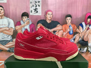 Side view of a red sneaker showing the mesh panel, script side detail, lace area, and layered outsole.