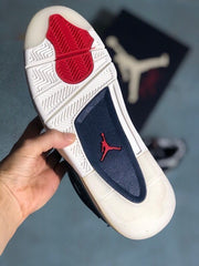 Bottom view showing the white traction outsole, red central traction insert, and dark blue forefoot section with a red Jumpman graphic.