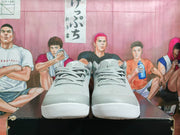 Front view of the pair of gray and white Nike sneakers showing the lace arrangement, perforated upper panels, toe boxes, and textured outsoles.