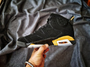 Side profile of a black and gold Jordan Air Jordan 6 sneaker showing its high-top construction and layered midsole.