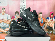 Angled view of black Nike GT basketball sneakers with silver accents and patterned outsoles.