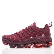 Side profile of a burgundy Nike sneaker with a segmented translucent sole.