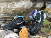 Two angled views of the black high-top shoes with patterned side panels.