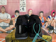 Rear view of black Nike basketball sneakers with blue accents, padded collars and translucent soles.