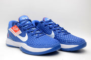Pair of blue basketball sneakers with white Swooshes, red tongue stitching, and a visible durability hangtag.