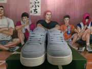 Front view of blue and gray lace-up sneakers with padded tongues and textured rubber outsoles.