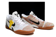 Pair of white and multicolor shoes with gum-colored outsoles and a dark box behind them.