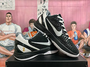 Angled view of black and white basketball shoes showing the textured upper and contrasting side details.
