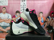 Pair of black, white, and pink Jordan basketball-style sneakers displayed on a black shoebox.