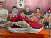 Side profile showing the gold Swoosh-style detail, white side panels, red accents, and layered white midsole.