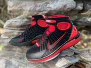 Angled product view showing the padded collar, side detailing, and red midsole accents.