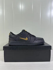 Side profile of the black low-top sneaker showing a gold-tone side logo and textured panel details.