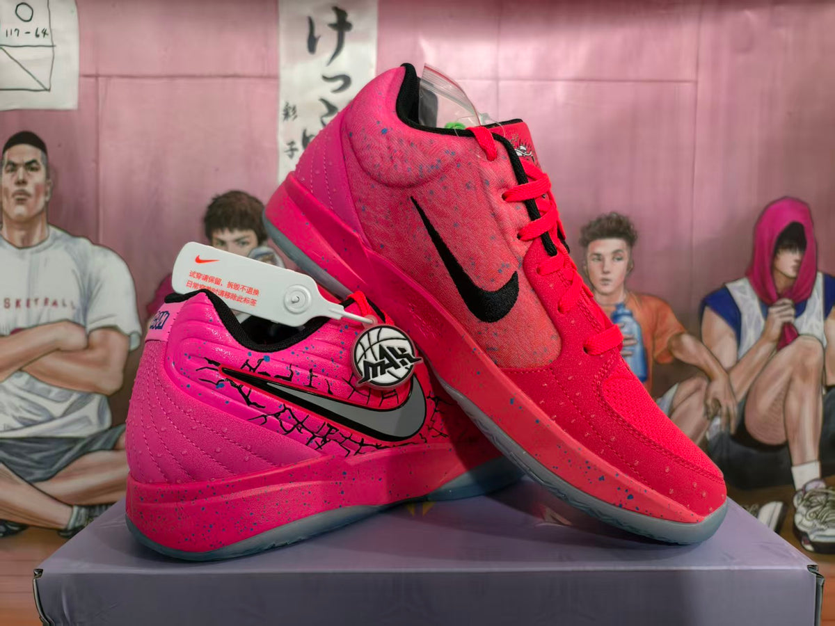 Pair of pink and red basketball shoes with black side logos and speckled detailing