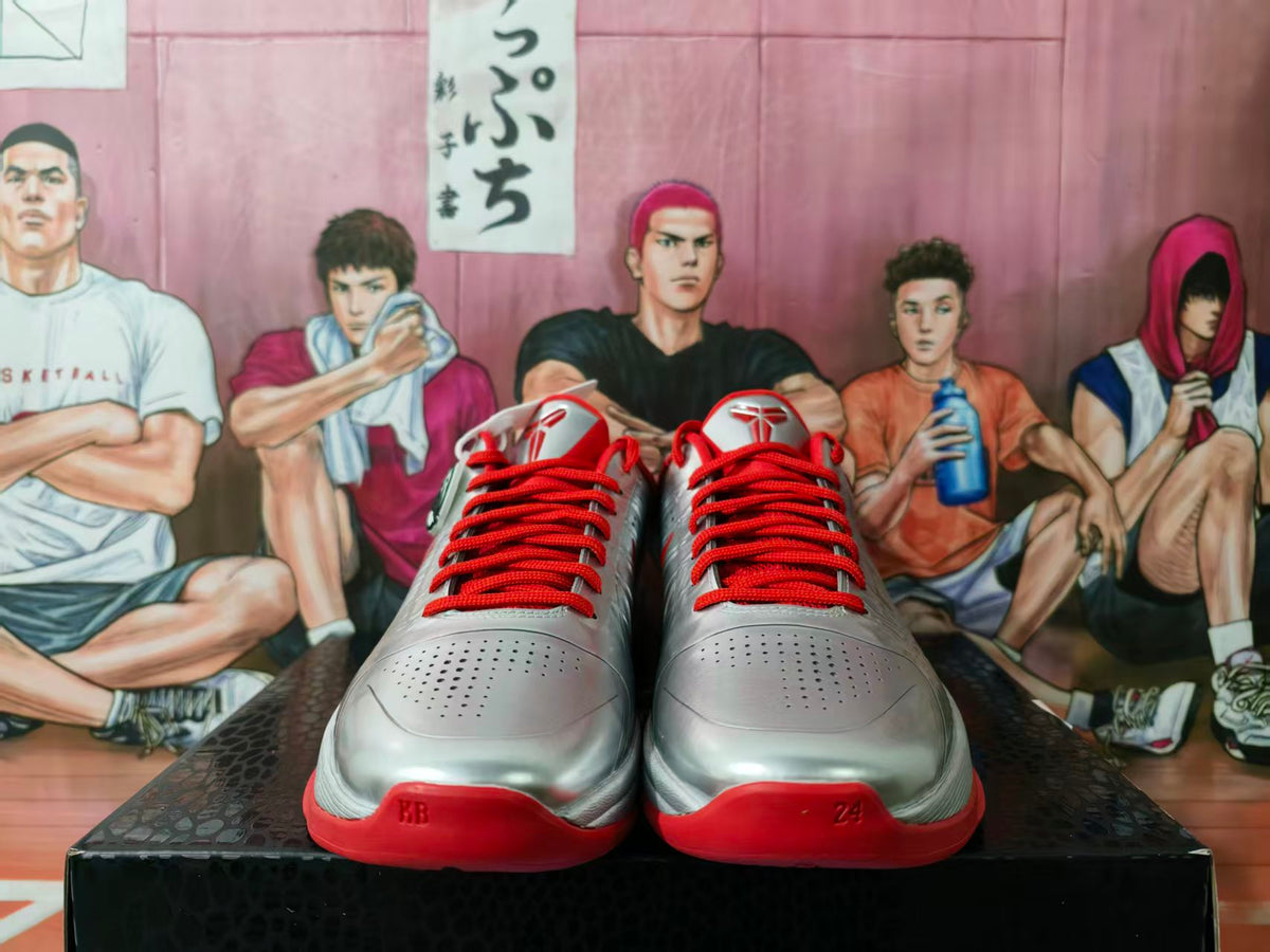 Front view of silver Nike basketball sneakers with red laces, red outsoles and perforated toe panels.