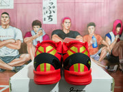 Rear view of the pair showing black heel panels, red and gold vertical detailing, and red outsoles.