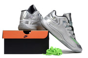 Silver Nike KD 18 sneakers arranged with a shoebox and green laces.