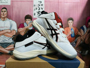 Pair of white ASICS basketball shoes with black side detailing and rust-red tongues