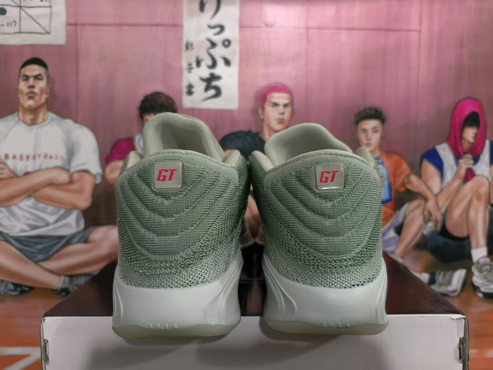 Rear view of green Nike GT-style basketball sneakers showing textured uppers, GT heel labels, and translucent outsoles.