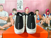 Rear view of a pair of black and white sneakers showing the heel panels and “NIKE WRESTLING” branding.