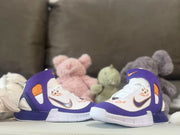 Pair of sneakers shown from the side against a soft toy background.