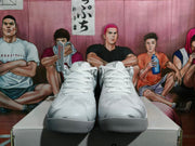 Front view of the white and gray basketball sneakers showing white laces, rounded toe boxes, and textured outsoles.