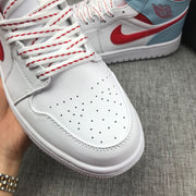Close-up of the perforated toe box, white laces with red detailing, and side Swoosh.
