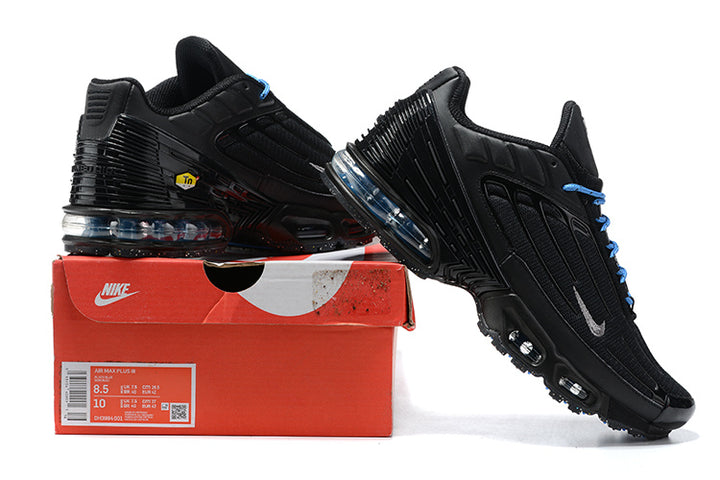 Black Nike Air Max Plus sneakers with blue laces and accents displayed on a shoebox; box label shows size 8.5 and 10.