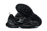 Black and silver graphic low-top sneakers shown from the side with one shoe displaying the treaded outsole.