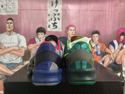 Rear view of a mismatched Nike basketball shoe pair, showing contrasting blue and green heels.