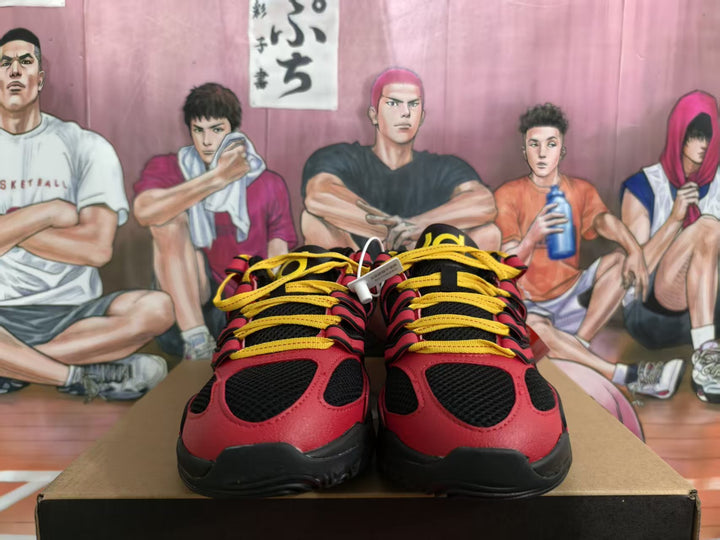 Front view of red and black Nike sneakers with yellow laces displayed on a box.
