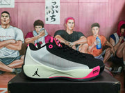 Side view of a black and white Jordan sneaker with pink accents and visible Air Zoom lettering.