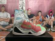 Side view of one sneaker showing gray patterned panels, coral-red and green knit sections, a contrasting Nike swoosh, and a white sole.