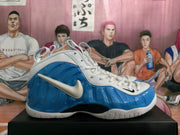 Side profile showing the glossy blue molded-looking upper, white Swoosh, white overlays, and black midsole section.